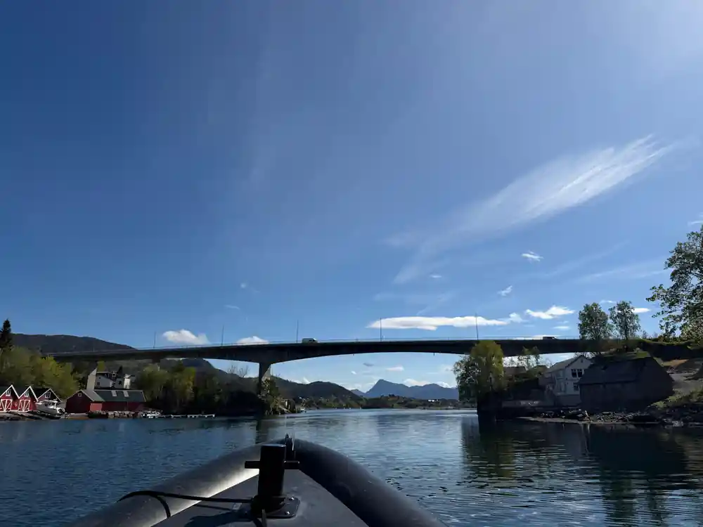 The boat passing under a bridge on calm water