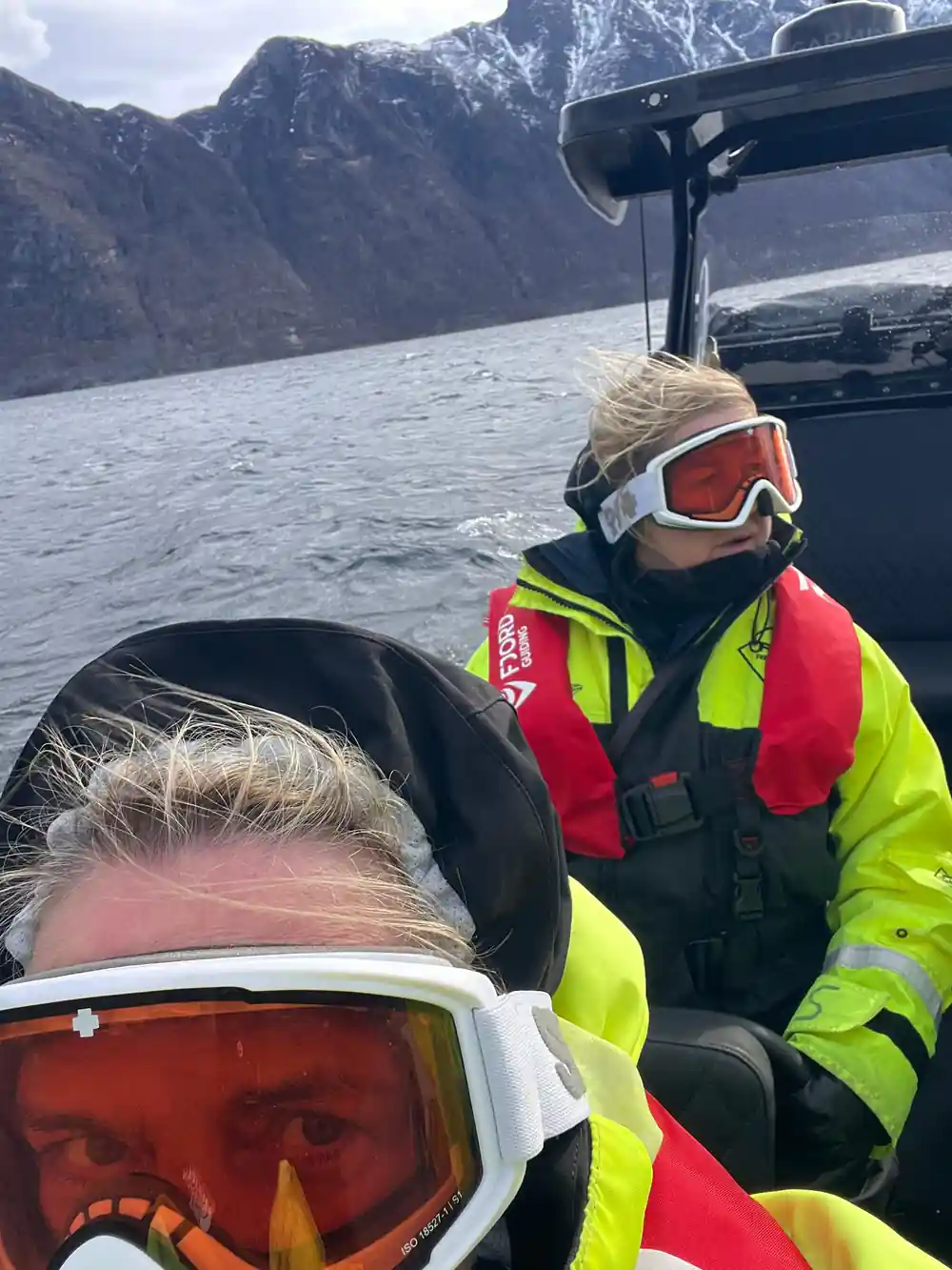 A passenger in goggles resting against the seat back