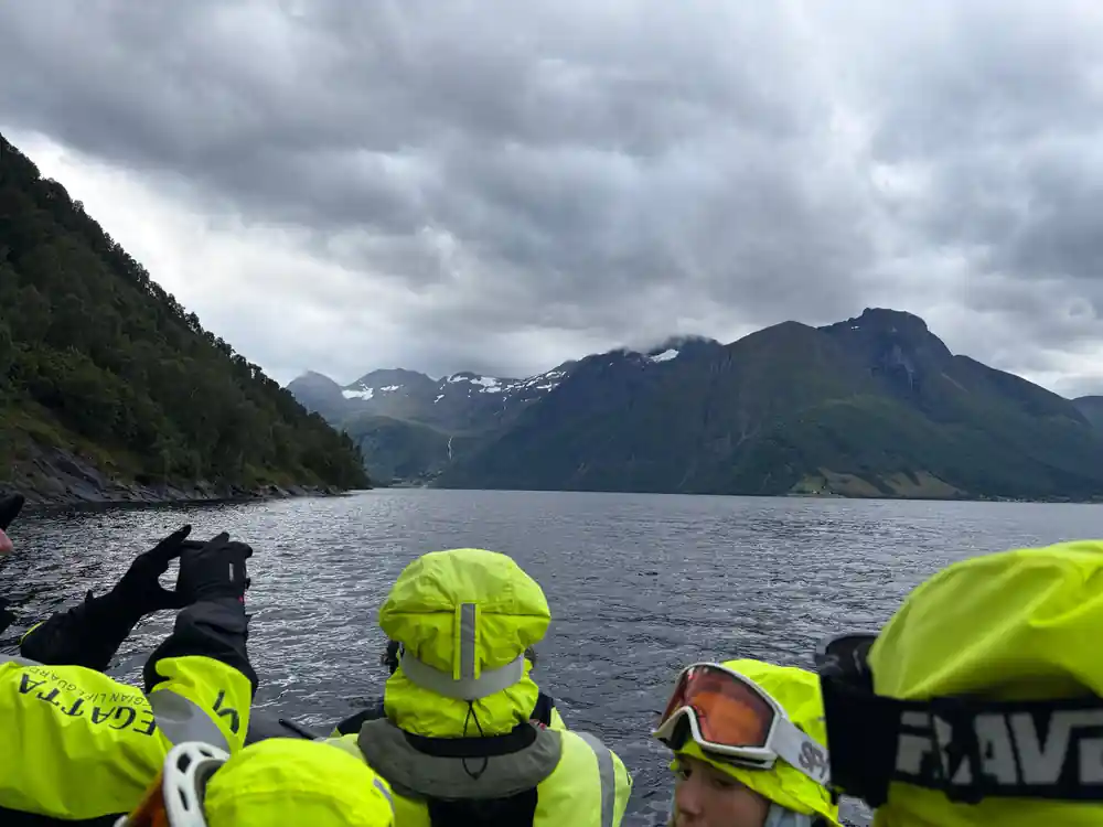 Passengers in goggles looking out at the mountains