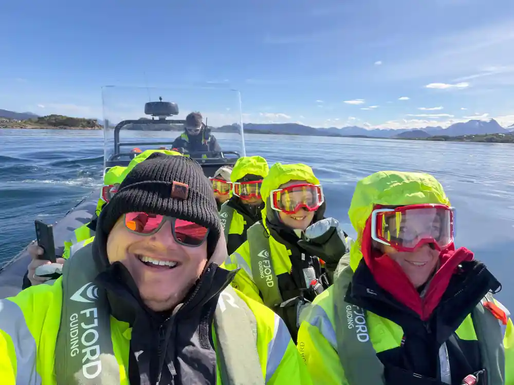 Passengers in goggles smiling aboard under a blue sky