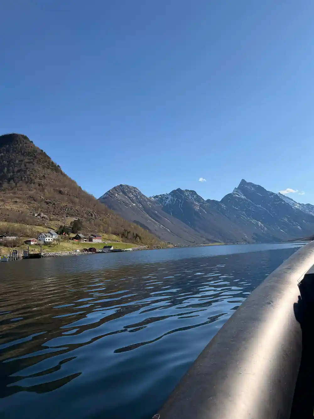 Peaks above a shoreline with a few houses at the water