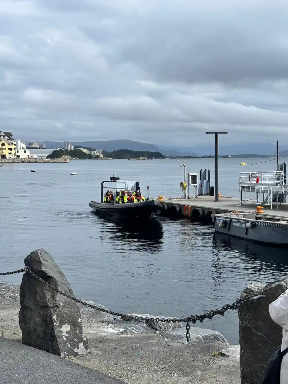 The RIB coming alongside a pontoon with the town behind