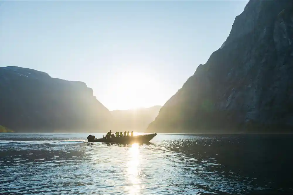 The RIB silhouetted against the sun at the head of the fjord