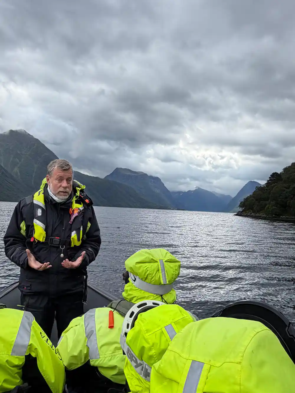 The skipper explaining something with the fjord behind