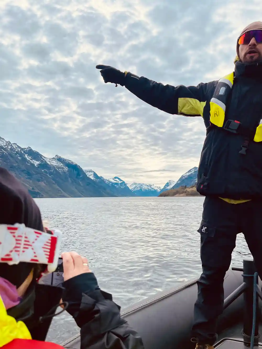 The skipper pointing out something across the water