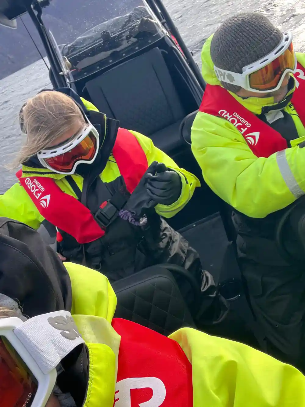 Two passengers in red and yellow suits seated aboard