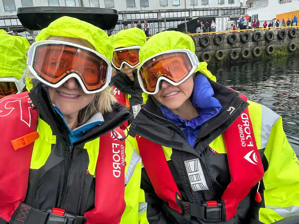 Two passengers in suits and orange goggles on the quay